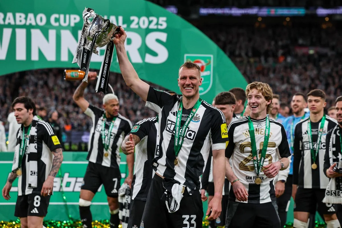 Newcastle United's Dan Burn lifts the cup after the Carabao Cup Final 